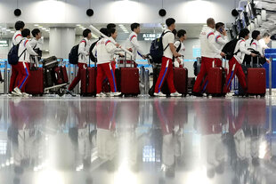 Sportler mit Koffern am Flughafen