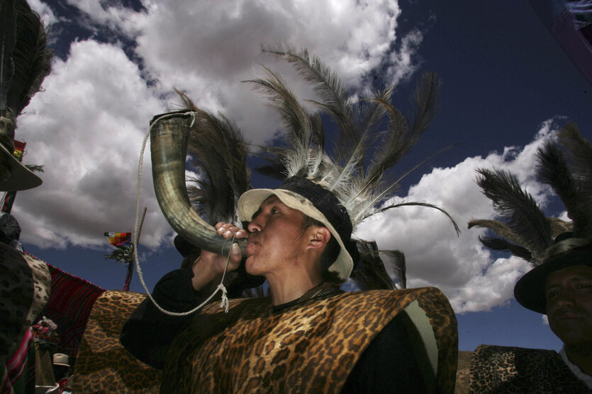Indigene Völker aus Chile treten während des kulturellen Treffens der indigenen Aymara Südamerikas auf dem Hügel Quimsa Chata in der nördlichen Stadt Tiwanaku auf. Eine Person mit Federkopfschmuck bläst in ein Horn