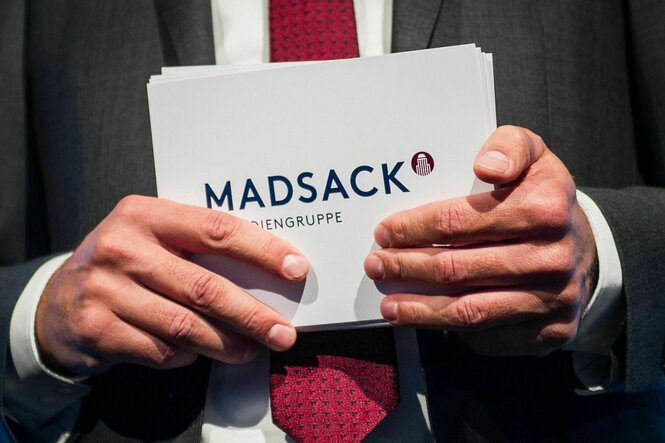 Moderationskarten mit der Aufschrift "Madsack" in Händen