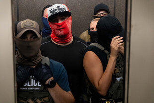 vermummte Menschen im Fahrstuhl