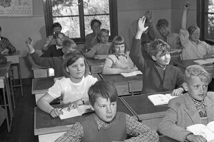 Historisches Foto eines Klassenzimmers mit vielen Schülern und Schülerinnen