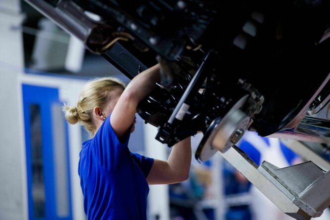 Eine weibliche Monteurin am Fliessband in der Fertigung im Werk der VW AG Wolfsburg