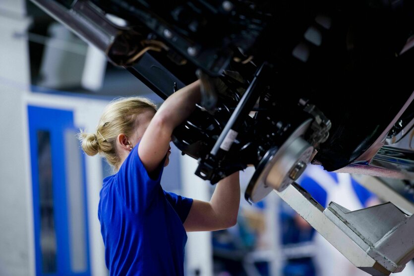 Eine weibliche Monteurin am Fliessband in der Fertigung im Werk der VW AG Wolfsburg