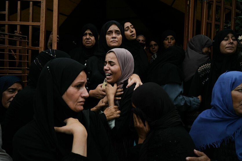 Eine Gruppe von Frauen steht aufgebracht zusammen