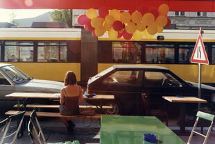 Eine Person sitzt alleine in einem Straßencafé.