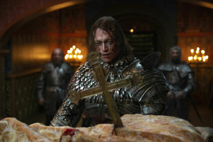 Ein Mann in Ritterrüstung mit Blut im Gesicht