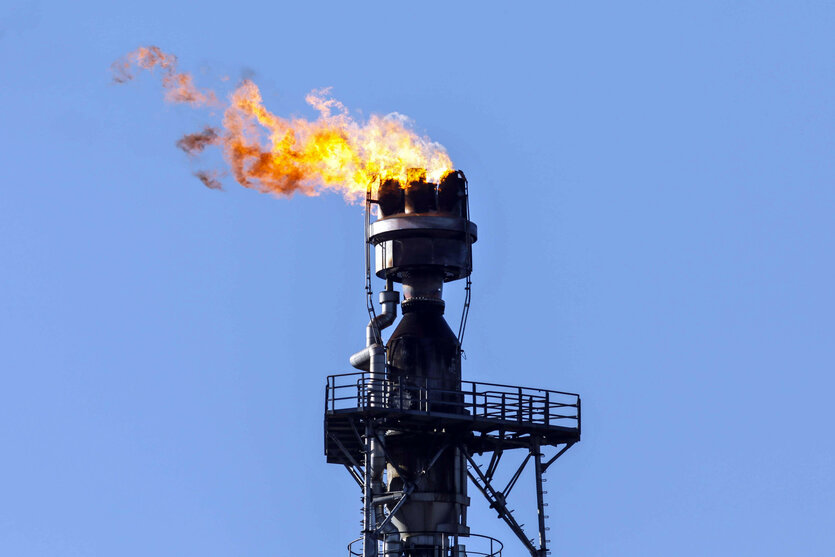 Aus dem Turm einer Erdölraffinerie kommen Flammen