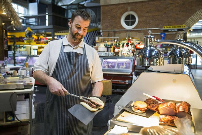 Ein Koch serviert einen Schinken.