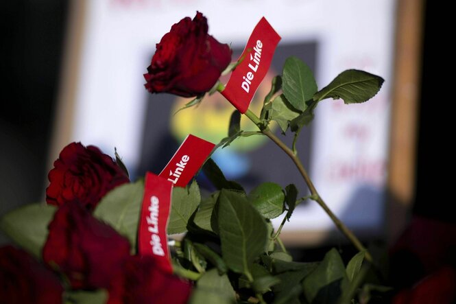 Rote Rosen mit Logo der Partei Die Linke versehen