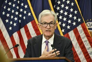 Jerome Powell steht an einem Rednerpult vor US-Flaggen