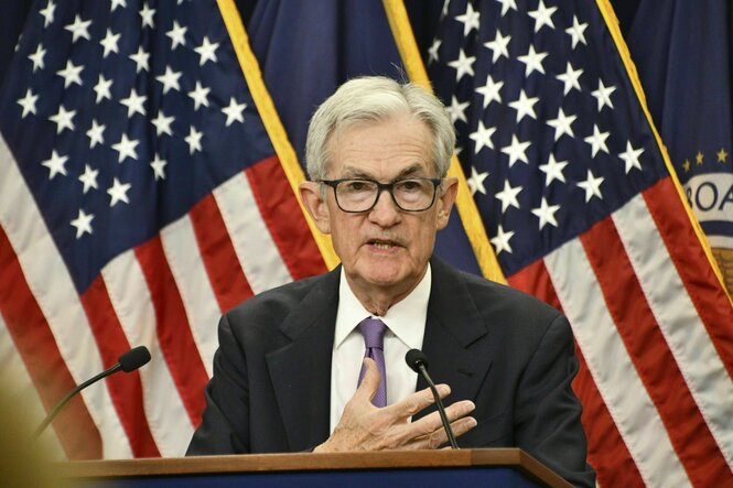 Jerome Powell steht an einem Rednerpult vor US-Flaggen