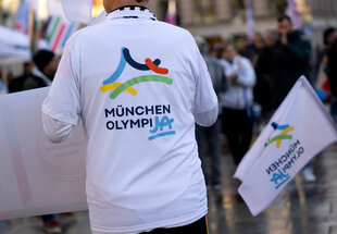 Befürworter einer Olympiabewerbung mit Aufschrift "München OlympiJa" auf Shirt bei einer Kundgebung