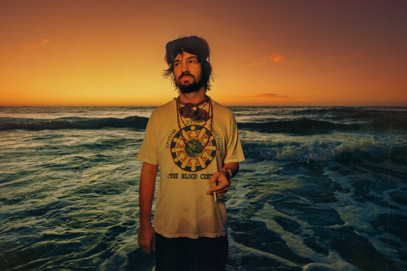 Ein Mann steht bei Sonnenuntergang am Meer