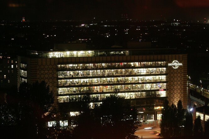 Universal-Gebäude an der Oberbaumbrücke in Berlin bei Nacht, das Innere hell erleuchtet