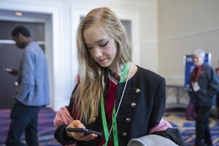 Naomi Seibt schaut auf ihr Handy