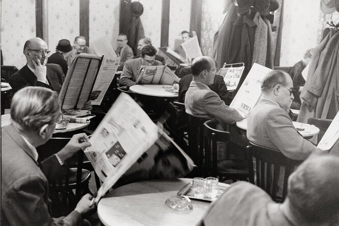 Schwarz-weiß-Foto von ganz vielen Herren, die Zeitung lesen