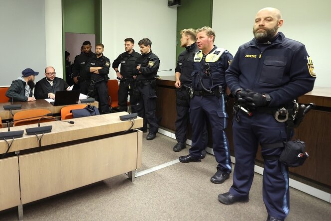 Blick in einen Gerichtssaal, viele Polizisten haben sich darin aufgestellt