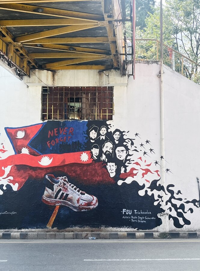 Ein Graffito zeigt einen blutigen Turnschuh und eine Gruppe von Gesichtern