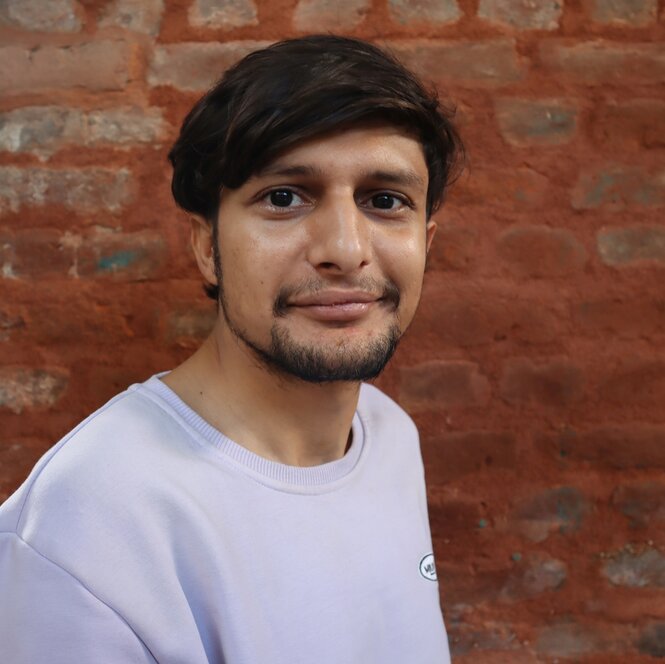 Ein junger Mann lächelt in die Kamera