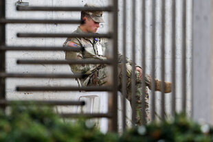Soldat vor grauem Gebäude sitzend