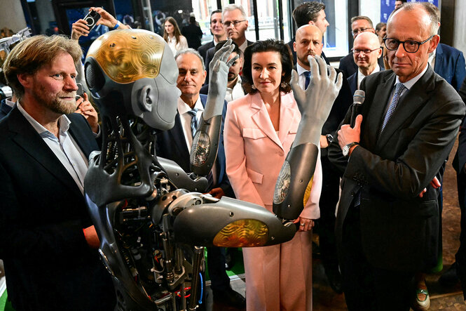 Dorothee Bär, Friedrich Merz und andere schauen einen Roboter an