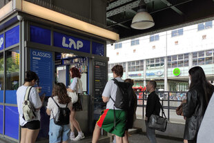 Leute stehen für Kaffee der Kette LAP Coffee an