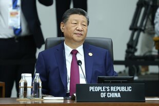 Xi Jinping sitzt vor einem Mikro