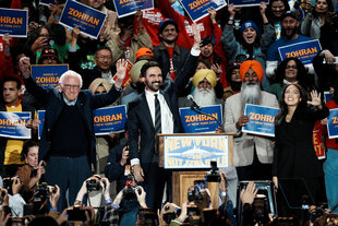 Bernie Sanders, Zohran Mamdani und Alexandria Ocasio-Cortez stehen gemeinsam auf einer Bühne