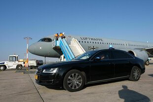 Gepanzertes schwarzes Auto vor einem Flugzeug der deutschen Luftwaffe