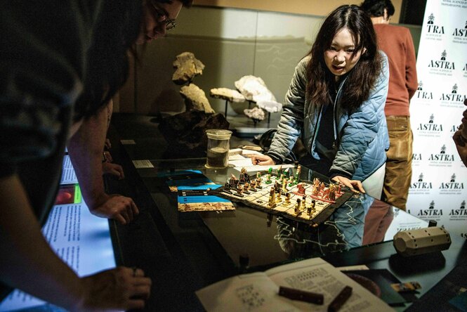 Besucher*innen an einem Brettspiel-Stand unter anderem mit Schachspiel bei der Berlin Science Week
