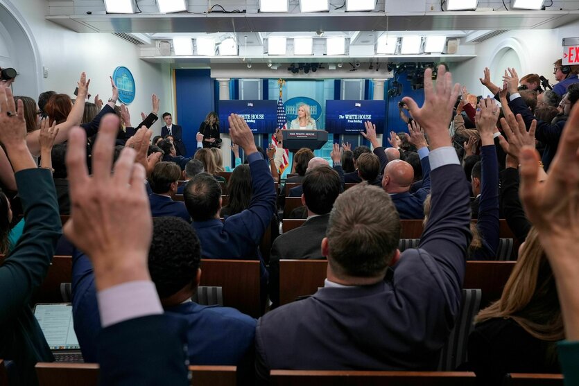 Journalisten heben bei einer Pressekonferenz die Hände um Fragen zu stellen