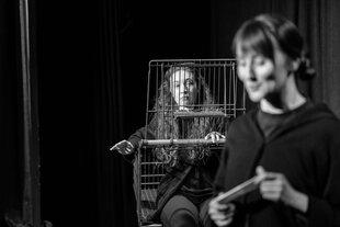 Szene in Schwarzweiß aus "Die Geschichte der Fluchttiere", zwei Frauen reden miteinander, eine sitzt in einem Einkaufswagen