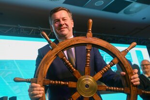 Ein Mann hält ein Steuerrad in seinen Händen