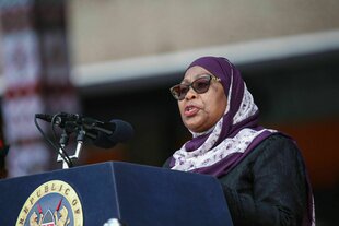 Eine Frau mit Sonnenbrille steht an einem Rednerpult