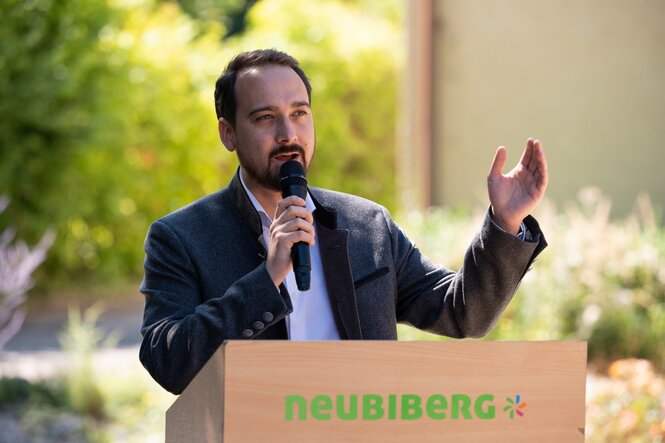 Thomas Pardeller steht an einem Rednerpult und spricht in ein Mikrofon