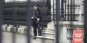 Ein bewaffneter Polizist steht vor einem Haus in der Downing treet