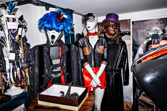 Schaufensterpuppen tragen Lederoutfits und Masken.