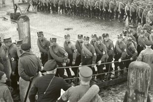 Eine lange Schlage von SA-Wachleuten besteigt ein Boot