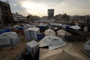 Zelte vor zerstörter Stadt