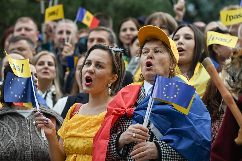 Frauen singen und tragen Fahnen und Fähnchen, auch ein Europafähnchen