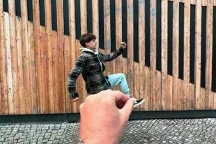 Eine Hand reicht ins Bild und bewegt einen Mann