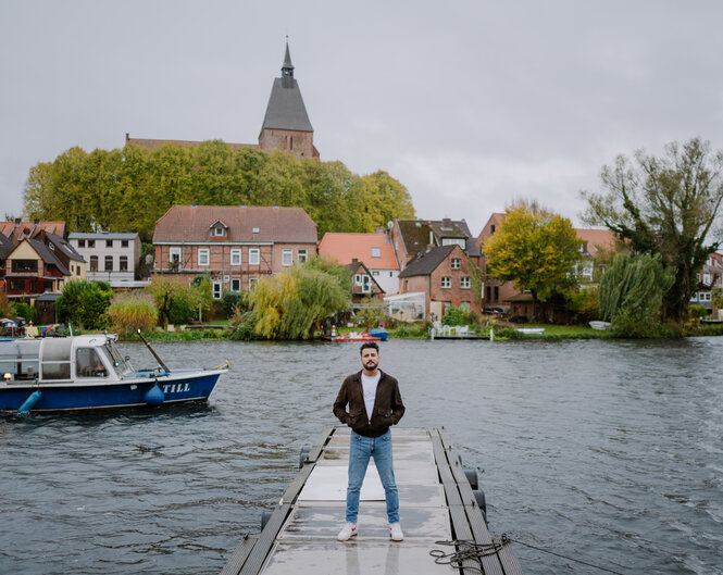 Ein Mann steht auf einem Bootssteg