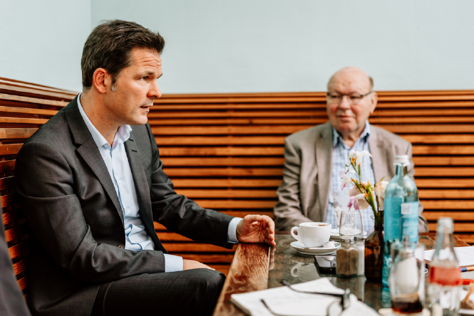 Steffen Krach und Walter Momper im Gespräch an einem Cafétisch