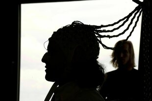 Ein Schattenriss zeigt eine Person im Profil, eine weitere Person ist im Hintergrund zu sehen