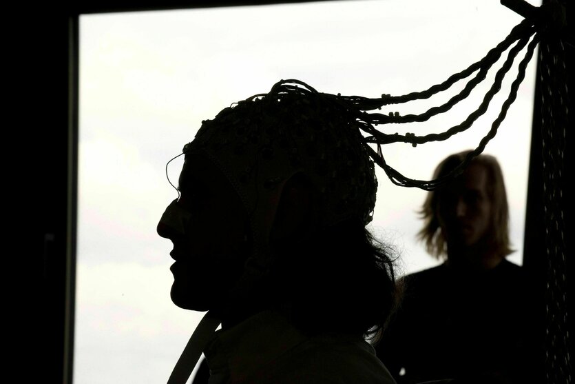 Ein Schattenriss zeigt eine Person im Profil, eine weitere Person ist im Hintergrund zu sehen