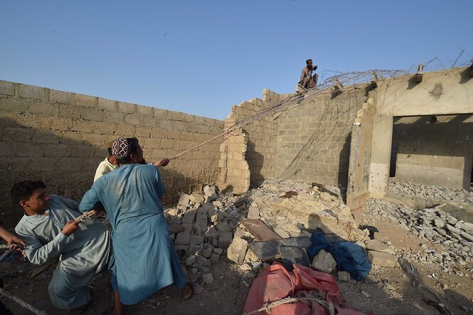 Menschen stehen in einer Hausruine