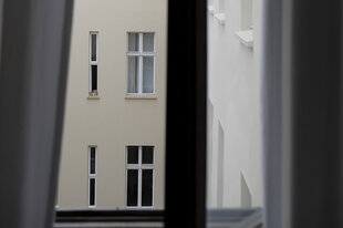 Blick aus einem Fenster auf die Fenster von Hinterhofwohnungen