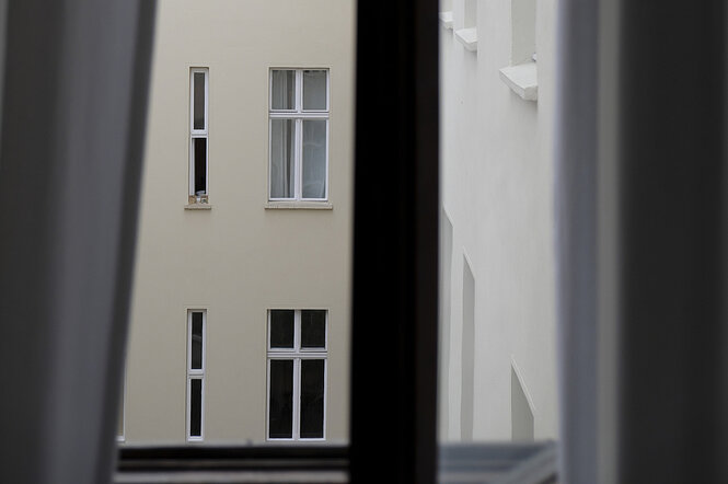 Blick aus einem Fenster auf die Fenster von Hinterhofwohnungen