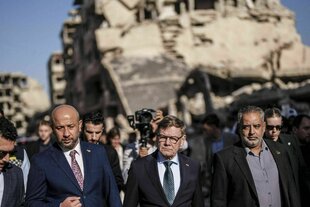 Johann Wadephul unterwegs in Damaskus, hinter ihm sind zerstörte Häuser zu sehen