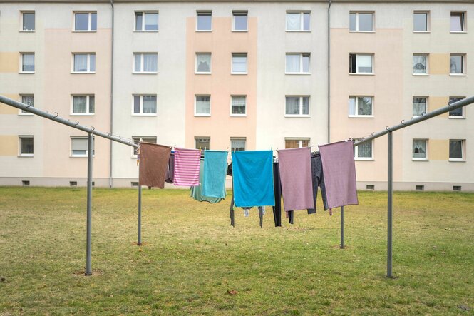 Wäsche hängt an der Leine vor einem Wohnblock